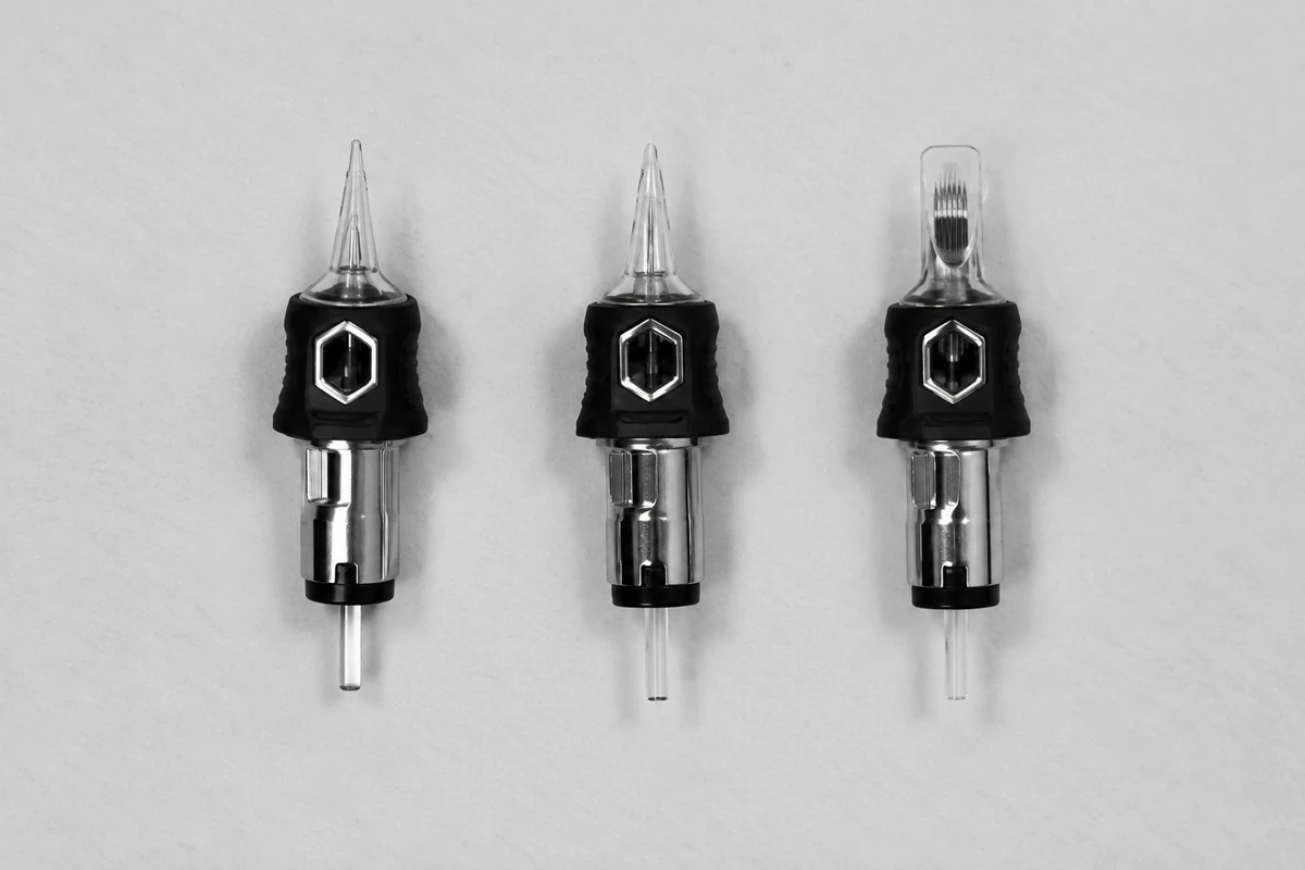 Trois cartouches de tatouage montrées côte à côte.